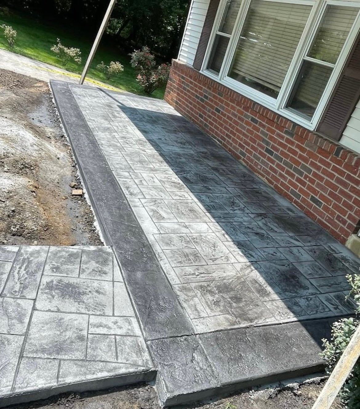 Decorative stamped and stained concrete patio built by Fox and Fern